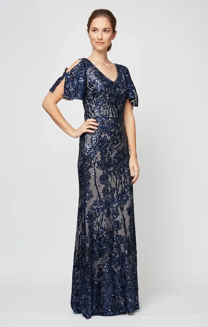 A woman wearing a long, dark blue sequin dress with short, open sleeves, standing in a neutral pose.